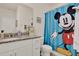 Bathroom featuring granite countertop, white cabinets, and a Mickey Mouse themed shower curtain at 11006 Sound Shore Dr, Winter Garden, FL 34787
