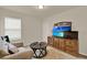 Cozy bedroom features plush carpet, a side table, natural light, and modern entertainment system at 11006 Sound Shore Dr, Winter Garden, FL 34787