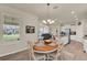 Bright dining area with a wooden table, chandelier, and open view to the kitchen and living room at 11006 Sound Shore Dr, Winter Garden, FL 34787