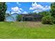 Lush backyard featuring a screened pool enclosure, mature trees, patio and shed at 1032 Silcox Branch Cir, Oviedo, FL 32765
