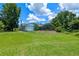 Expansive backyard with screened enclosure, storage shed, mature trees, and lush lawn at 1032 Silcox Branch Cir, Oviedo, FL 32765