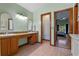 Well-lit bathroom with dual sinks and vanity, featuring a view into the main bedroom at 1032 Silcox Branch Cir, Oviedo, FL 32765