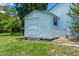 Close-up of a white storage shed in the backyard with an access door and window at 1032 Silcox Branch Cir, Oviedo, FL 32765