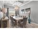 Elegant dining room featuring a glass-top table, stylish chairs, modern chandelier and neutral decor at 1035 Stoney Creek Dr, Lakeland, FL 33811