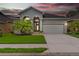 Charming single-Gathering home with well-manicured lawn, tropical landscaping, and a two-car garage at sunset at 1035 Stoney Creek Dr, Lakeland, FL 33811