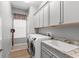 Well-lit laundry room features modern appliances, cabinets, sink, and neutral gray walls at 1035 Stoney Creek Dr, Lakeland, FL 33811