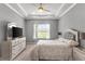 Bright main bedroom featuring a large window, plush bedding, neutral decor, and a modern entertainment center at 1035 Stoney Creek Dr, Lakeland, FL 33811