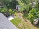 Aerial view of a home with a big backyard, patio, and storage shed in a wooded neighborhood at 1089 Algoma St, Deltona, FL 32725
