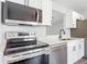Close up shot of a modern kitchen featuring stainless steel appliances and white cabinets at 1089 Algoma St, Deltona, FL 32725