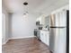 Open kitchen featuring modern stainless steel appliances, white cabinets, and hardwood floors at 1089 Algoma St, Deltona, FL 32725