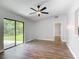 Light-filled living room with wood-look floors and sliding glass door to the outdoors at 1089 Algoma St, Deltona, FL 32725