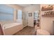 Bright bathroom features a glass enclosed shower, soaking tub, and natural light at 13940 Magnolia Ridge Loop, Winter Garden, FL 34787