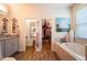 Bright bathroom featuring double sinks, soaking tub and a walk-in closet access at 13940 Magnolia Ridge Loop, Winter Garden, FL 34787