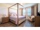 Relaxing bedroom with a stylish four-poster bed, chandelier, and plenty of natural light at 13940 Magnolia Ridge Loop, Winter Garden, FL 34787