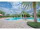 Inviting community pool featuring brick pavers, tables with umbrellas, lounge chairs, and mature landscaping at 13940 Magnolia Ridge Loop, Winter Garden, FL 34787
