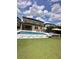 Spacious backyard featuring a swimming pool, outdoor seating, and lush green artificial turf at 14117 Larkspur Lake Dr, Winter Garden, FL 34787