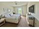 Bright bedroom featuring neutral walls, carpet, ceiling fan, and a large TV on dresser at 14117 Larkspur Lake Dr, Winter Garden, FL 34787