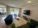 Bright living room showcasing a textured accent wall, modern lighting, and open access to the outdoor pool at 14117 Larkspur Lake Dr, Winter Garden, FL 34787