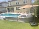 Outdoor oasis featuring a pool, lounge area, and well-manicured turf and privacy landscaping at 14117 Larkspur Lake Dr, Winter Garden, FL 34787