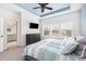 Bedroom showcasing three large windows, TV, and modern decor, flowing into ensuite bathroom at 14215 Lakeview Park Rd, Winter Garden, FL 34787