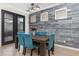 Contemporary dining room with a wooden table, upholstered chairs, modern lighting, and a decorative wood-paneled accent wall at 14215 Lakeview Park Rd, Winter Garden, FL 34787