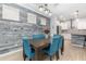 Well-lit dining area with a wooden table, upholstered chairs, modern lighting, and a view of the adjacent kitchen at 14215 Lakeview Park Rd, Winter Garden, FL 34787