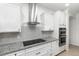Contemporary kitchen featuring white cabinets, granite countertops, stainless steel appliances, and sleek tile backsplash at 14215 Lakeview Park Rd, Winter Garden, FL 34787