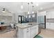 Bright, open kitchen features a granite island, stainless steel appliances, and modern pendant lighting at 14215 Lakeview Park Rd, Winter Garden, FL 34787