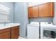 Functional laundry room with washer, dryer, sink, window, and built-in cabinetry at 14215 Lakeview Park Rd, Winter Garden, FL 34787