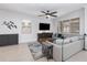 Cozy living room with light-colored walls, a comfortable gray sofa, a ceiling fan, and stylish decor at 14215 Lakeview Park Rd, Winter Garden, FL 34787