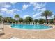 Community pool surrounded by lounge chairs, tropical landscaping, and clear blue water at 14215 Lakeview Park Rd, Winter Garden, FL 34787
