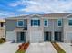 Charming townhome showcasing a well-maintained facade, single-car garages and manicured landscaping at 1518 Isleta Loop, Kissimmee, FL 34741