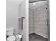 Modern bathroom featuring a tiled shower, toilet and grey walls at 15650 Catherine Cir, Groveland, FL 34736