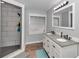 Bathroom with granite countertops, double sinks, wood-look floors, and large shower with tile surround at 15650 Catherine Cir, Groveland, FL 34736
