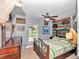 Cozy bedroom with wood accent wall, ceiling fan and natural light at 15650 Catherine Cir, Groveland, FL 34736