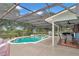 Screened-in pool and spa area with outdoor seating and grill, ideal for enjoying sunny days at 15650 Catherine Cir, Groveland, FL 34736