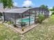 Landscaped backyard featuring a screened-in pool with a spa and seating area for outdoor enjoyment at 15650 Catherine Cir, Groveland, FL 34736