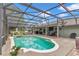 Screened-in pool area with a hot tub, outdoor seating, and a grill perfect for entertaining at 15650 Catherine Cir, Groveland, FL 34736