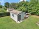 Backyard shed surrounded by lush green grass, offering extra storage space or a workshop area at 15650 Catherine Cir, Groveland, FL 34736