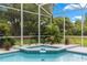 Tranquil hot tub within screened in pool enclosure provides relaxing spot with lush landscaping at 1700 Shandwick Ct, Longwood, FL 32779