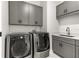 Well-equipped laundry room with gray cabinets, sink, and modern LG washer and dryer at 1700 Shandwick Ct, Longwood, FL 32779