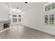 Living area with fireplace, light hardwood floors and large windows overlooking outdoor scenery at 1700 Shandwick Ct, Longwood, FL 32779