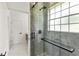 Luxurious tiled shower with glass enclosure, large window, and matte black hardware in updated bathroom at 1700 Shandwick Ct, Longwood, FL 32779