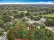 Drone image showcasing the property location with mature trees in the neighborhood with blue skies at 1701 Lucky Pennie Way, Apopka, FL 32712