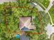 Aerial view of property showcasing mature trees, roof with solar panels and fenced-in backyard at 1701 Lucky Pennie Way, Apopka, FL 32712