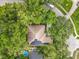 Aerial view of the home and neighborhood with mature trees, solar panels, and a round above ground pool at 1701 Lucky Pennie Way, Apopka, FL 32712