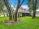 Back of house with mature trees, lush lawn, and screened in porch, perfect for outdoor entertaining at 1701 Lucky Pennie Way, Apopka, FL 32712