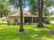 Back of house with mature trees, lush lawn, and screened in porch, perfect for outdoor entertaining at 1701 Lucky Pennie Way, Apopka, FL 32712