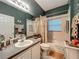 Well-lit bathroom with a shower-tub combo, neutral tile, and a white vanity providing storage space at 1701 Lucky Pennie Way, Apopka, FL 32712