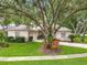 Well-maintained home with a lush front yard, mature trees, and a driveway at 1701 Lucky Pennie Way, Apopka, FL 32712
